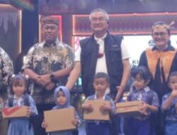 Bupati Malinau Wempi W Mawa menyerahkan secara simbolis bantuan perlengkapan sekolah kepada pelajar dalam program Wajib Belajar Malinau Maju 2025 di Panggung Budaya Padan Liu’ Burung, Jumat (24/10/2025) malam.